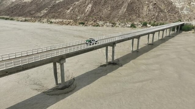 Aerial View Of Truck Driving On Hingol River Bridge. Parallax Shot