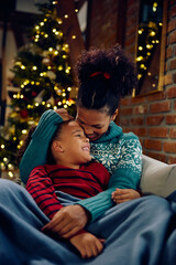 Affectionate black mother and daughter enjoying at Christmas at home.