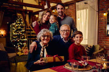 Happy extended family on Christmas eve at home looking at camera.