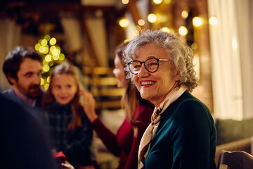 Happy senior woman enjoys in family gathering at home at Christmas.