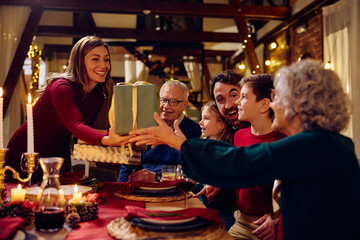 Little boy and his grandparents communicating at dining table on Christmas.