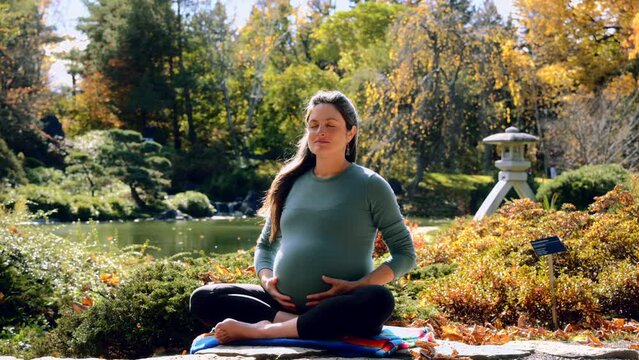 Pregnant Woman doing yoga pose in beautiful botanical garden in Montreal