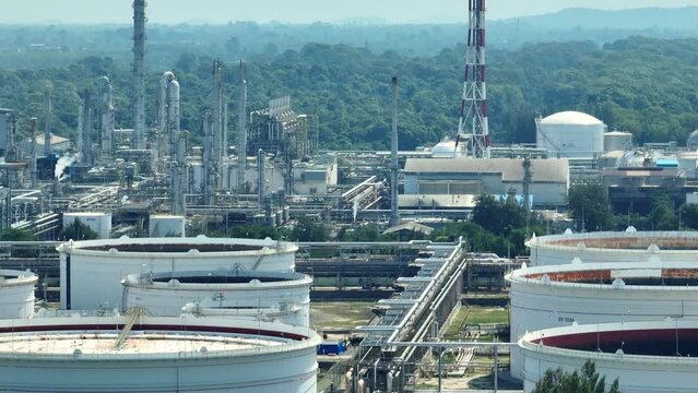 Aerial view via drone reveals an oil depot and refinery complex, a nexus of energy transformation. Precision engineering, pipelines, and storage tanks orchestrate the alchemy of hydrocarbons.

