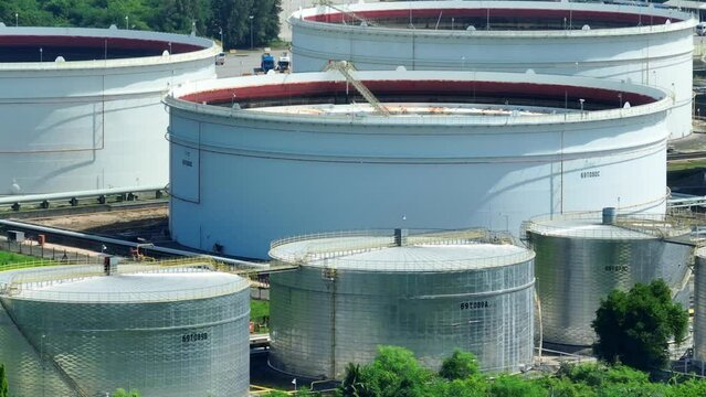 A drone soars above the sprawling oil depot, vast tanks glistening in the sun. A symphony of steel and pipes, it's a beacon of energy. Oil fuels global commerce, shaping economies.
