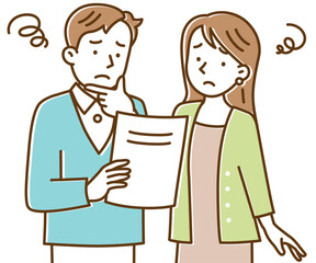 困った顔で書類を見る若い夫婦