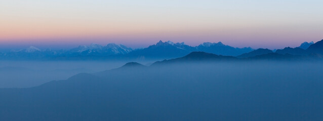 Beautiful himalayan mountain ridges in soft blue down light. Cover image format. - obrazy, fototapety, plakaty