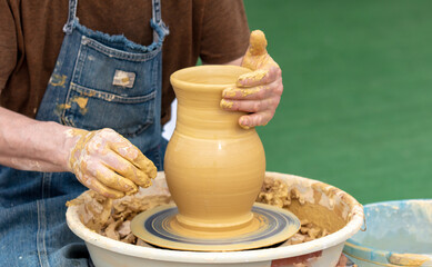 Clay craftsman sculpts crockery . Close-up.