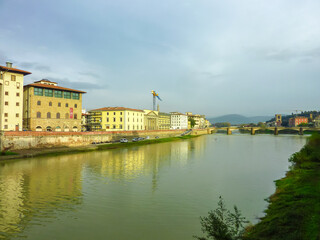 Scenic view from historic medieval Ponte Vecchio bridge on the Arno River, Florence, Tuscany, Italy, Europe. Landmark in Italian city on cloudy overcast day. Tourist travel destination