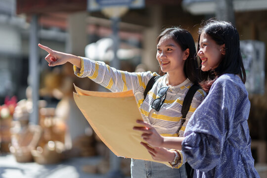 Traveler, two young female tourists, Asian backpacker with backpack looking at map The route around the craft market Weave in holiday, travel, trip and summer travel ideas.