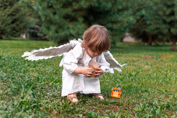 little boy in a city park dressed as an angel