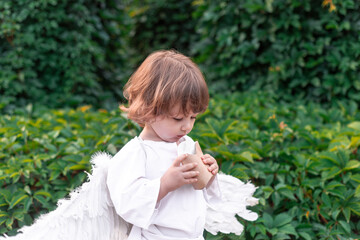 little boy in a city park dressed as an angel