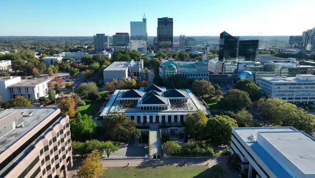 North Carolina state capitol building in downtown Raleigh, NC. High aerial orbit with skyline in background.