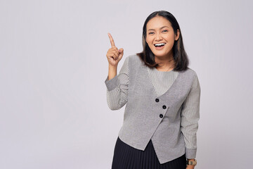 Smiling beautiful young Asian woman in casual clothes pointing fingers aside at copy space for your advertisement isolated on white background. People lifestyle concept