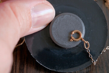pawnshop worker determines the golden chain using the magnet attraction, evaluation of gold items...