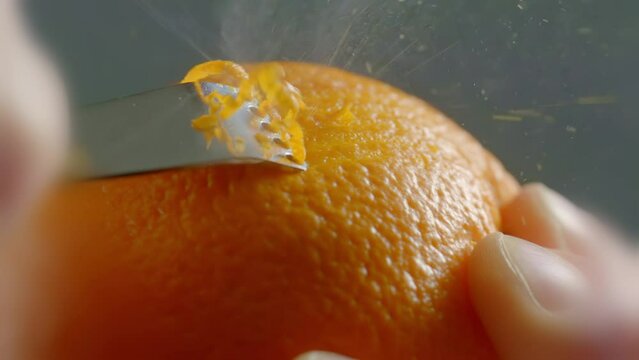 A Tool Crosses Along the Outside of an Orange to Peel the Zest