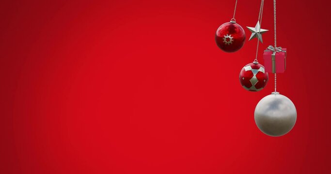 Animation of hanging baubles, star and gift box swinging against red background