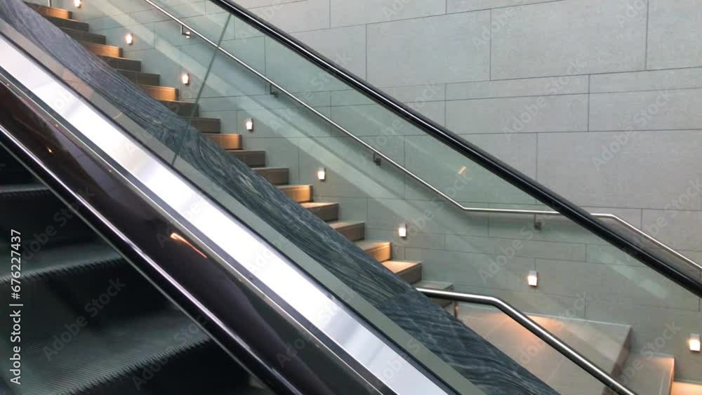 Poster view from the first person on an escalator looking to the stairs along the escalator at a building