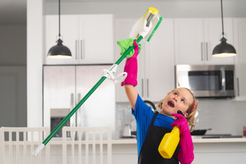 Housekeeping, home chores. Child use duster and gloves for cleaning. Funny child mopping house. Cleaning accessory, cleaning supplies. Housekeeping and home cleaning.