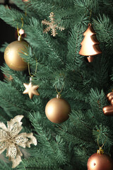 Christmas tree with gold balls on pink background. Christmas card with gold decor. Vertical photo