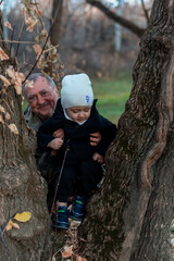 little boy in the autumn forest with his grandparents