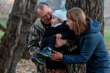 little boy in the autumn forest with his grandparents