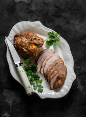 Delicious appetizer, tapas, snack - turkey pastrami on a white dish on a dark background, top view