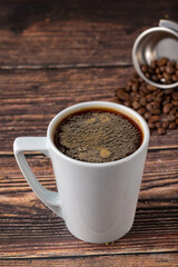 Relaxing americano coffee in black porcelain cup on wooden table