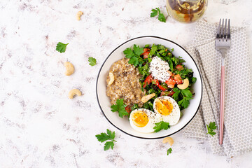Breakfast oatmeal porridge with boiled eggs and fresh salad. Healthy balanced food. Trendy food. Top view