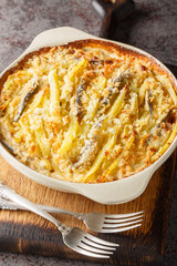 Traditional Swedish delicacy Jansson's Frestelse casserole of potatoes, onions, anchovies, and rich cream, often enjoyed during Christmas closeup on the baking dish on the table. Vertical