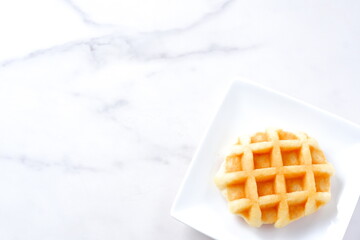 バターをたっぷり使って焼き上げた格子模様の洋菓子のワッフル
