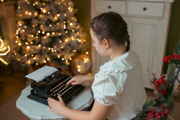 Christmas atmosphere with a vintage typewriter and girl writing letter to Santa