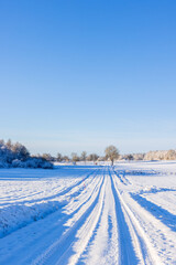 Fototapeta na wymiar Car tracks in the snow on a winter road