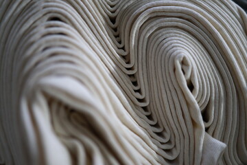 Rolled fabric on roller. Gray color fabric. Texture for background