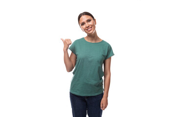 young confident slender woman dressed in a green basic t-shirt with a mockup points her hand towards the advertisement