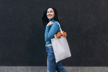 Young woman with white tote cotton bag on her shoulder. Mockup and zero waste concept.