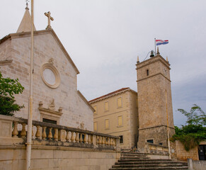The 17th century Parish Church of the Annunciation and bell tower in Supetar on Brac Island in Croatia. On the right, the free standing Leroj Clock Tower, 18th century