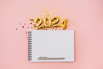 Happy New year and Christmas holiday concept 2024 with empty notebook and pen on pink background - obrazy, fototapety, plakaty