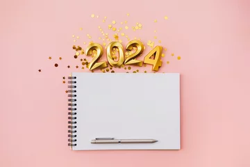 Foto op Canvas Happy New year and Christmas holiday concept 2024 with empty notebook and pen on pink background © olyphotostories