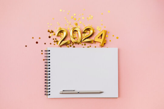 Happy New year and Christmas holiday concept 2024 with empty notebook and pen on pink background