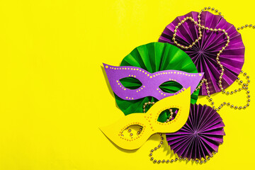 Festive Mardi Gras masquerade yellow background. Fat Tuesday carnival, masks, beads, traditional...