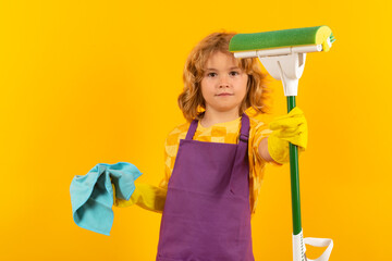 Child cleans at home concept. Kid cleaning with mop to help with housework. Little cute boy...