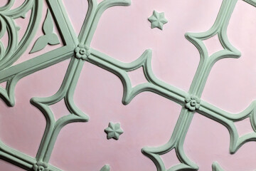 Ceiling design elements. Light green gypsum bas-relief over pink