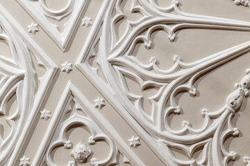 White gypsum bas-relief ceiling design details over beige paint - obrazy, fototapety, plakaty
