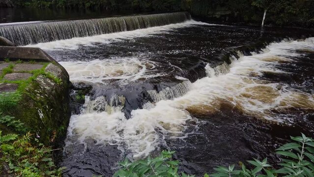 Closeup of the river Navy flowing over four weirs just after passing the English town of Tavistock in the county of Devon