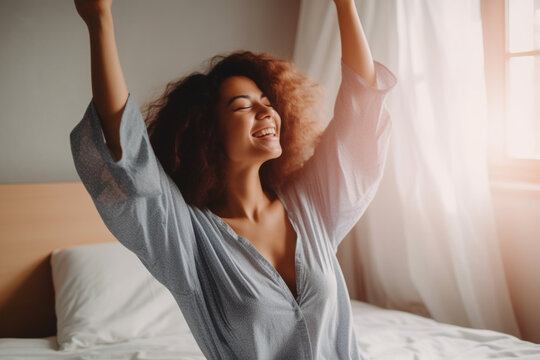 Portrait of a Happy Woman Waking Up and Stretching in Bed