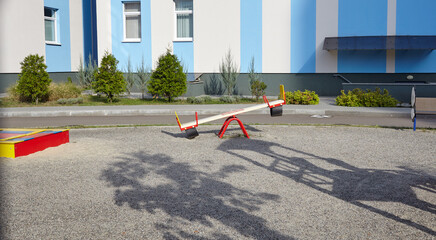 Facade of kindergarten building. Colorful playground for childrens on a sunny day