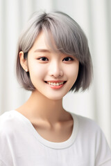 Fototapeta premium close up of an Asian woman with smooth skin gazing at the camera against a white backdrop, illuminated by studio lights.