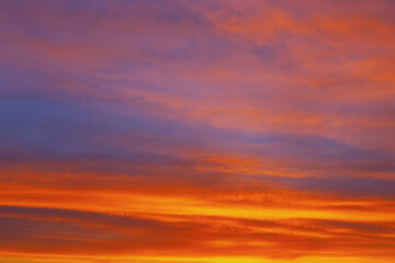 Fototapeta premium Tranquil canvas of the evening sky with red wavy clouds