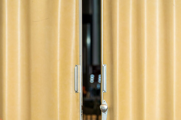 Bi fold,yellow open door,also known as accordion door. Practical usage.Silver handle. Background....