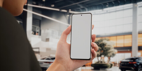 CU Caucasian woman using his phone inside the car dealership